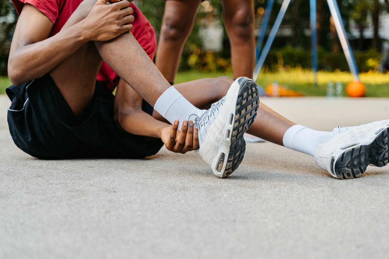 athletic person touching their ankle