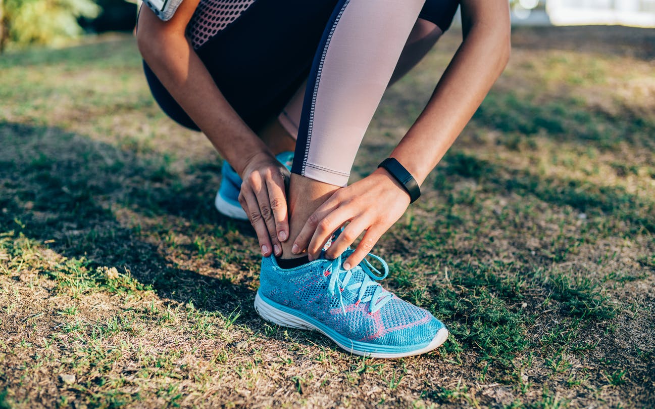 athletic person holding their ankle