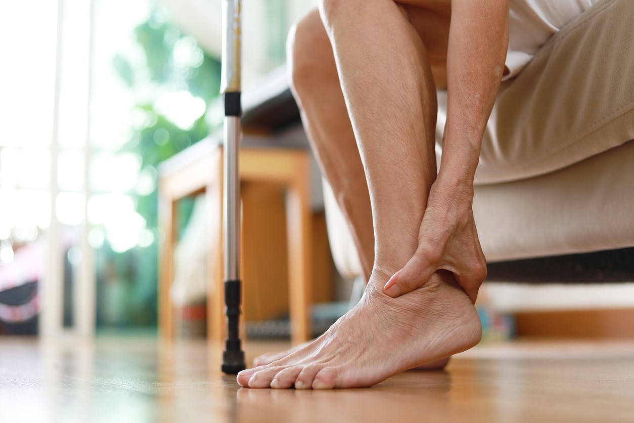 hand holding ankle bare foot