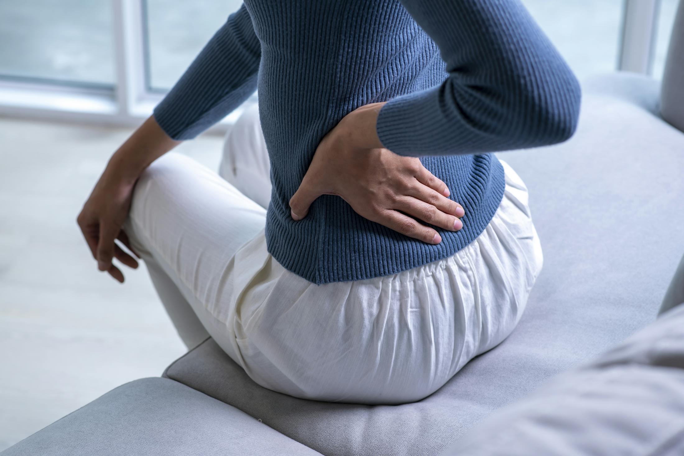 woman in blue shirt holding hip