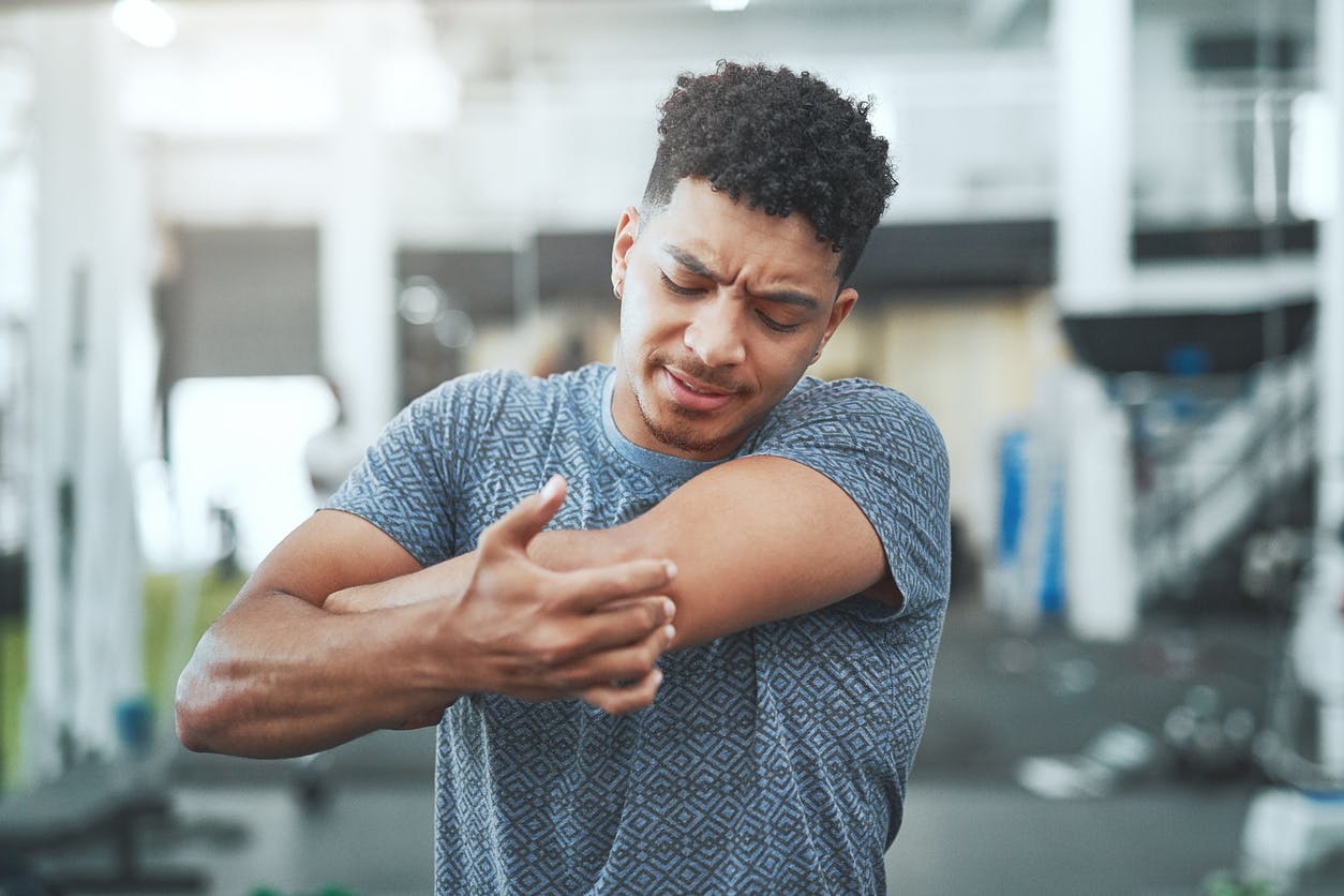 man reaching for his elbow