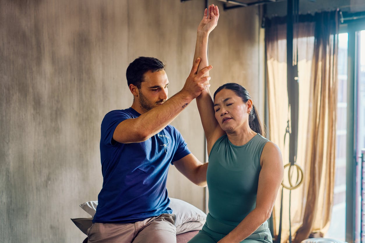 woman wearing green shirt stretching her arm