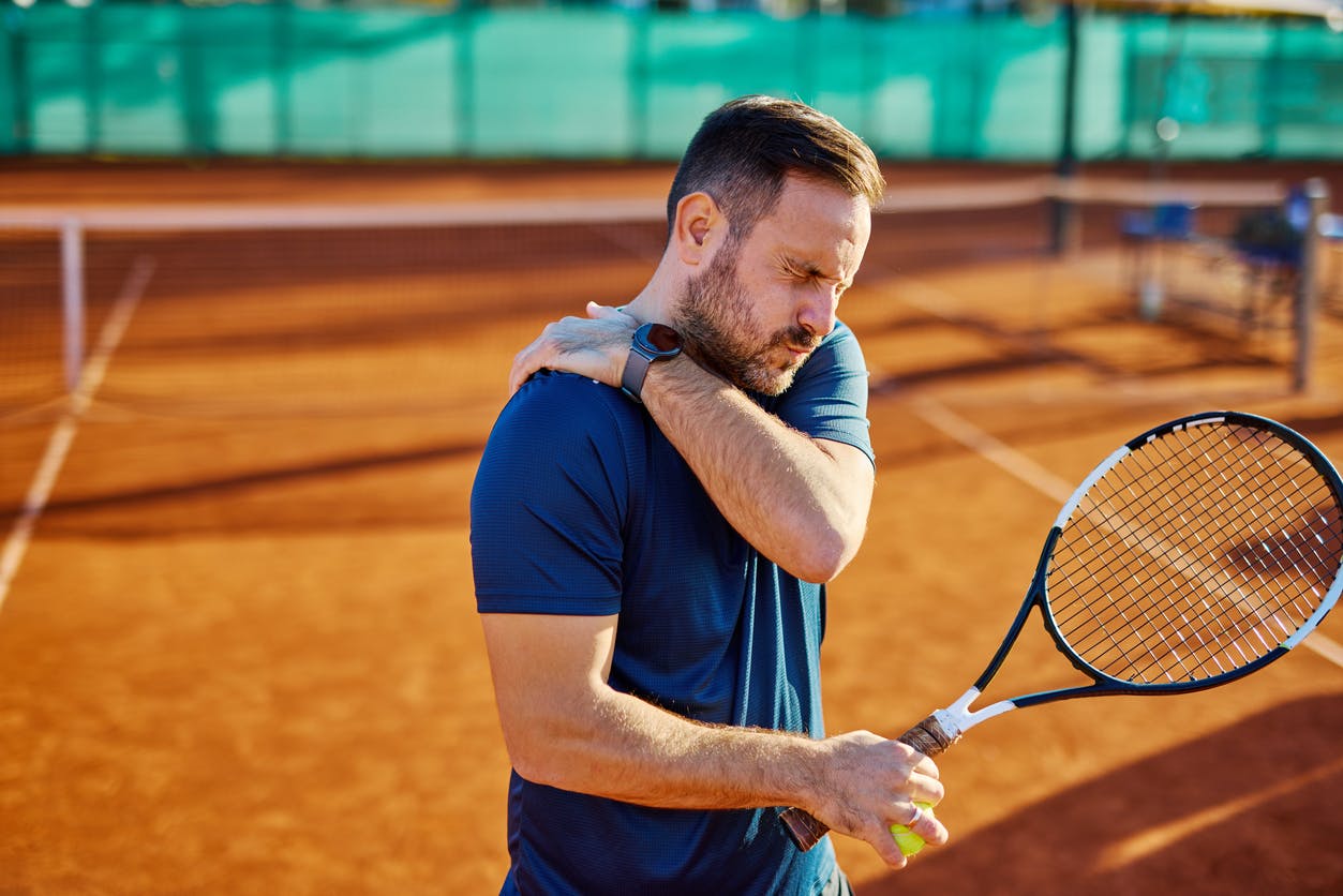 man on tennis court in pain