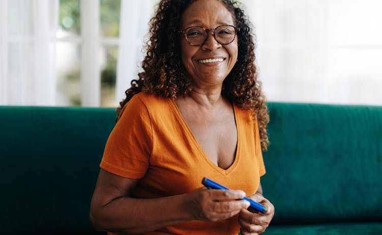 older lady in orange shirt smiling