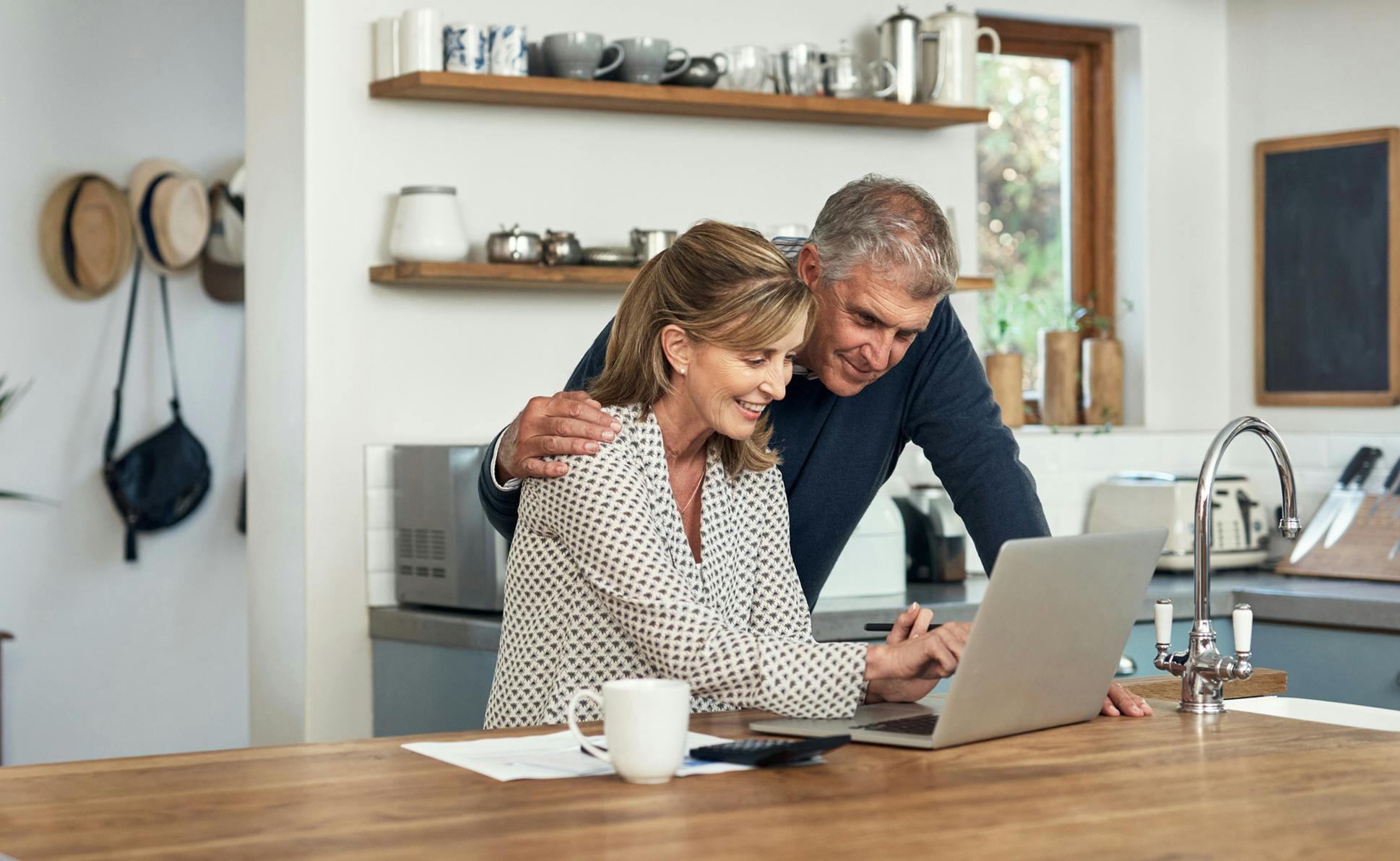 couple looking at laptop in kitchen