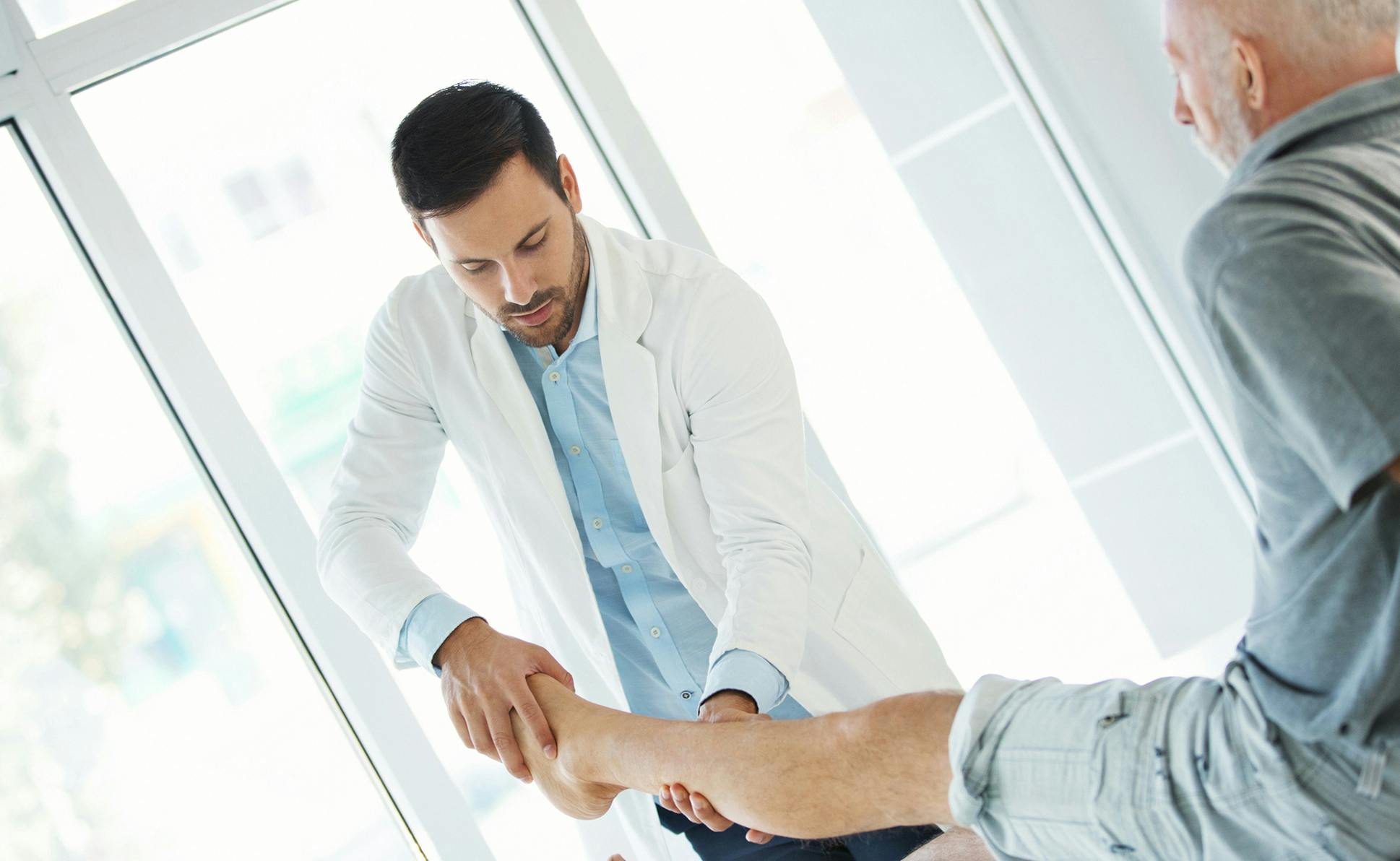 doctor holding clients leg and foot