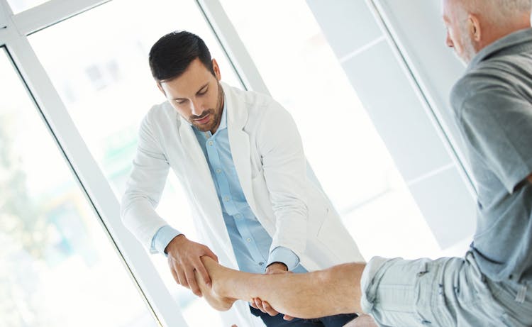 doctor holding clients leg and foot