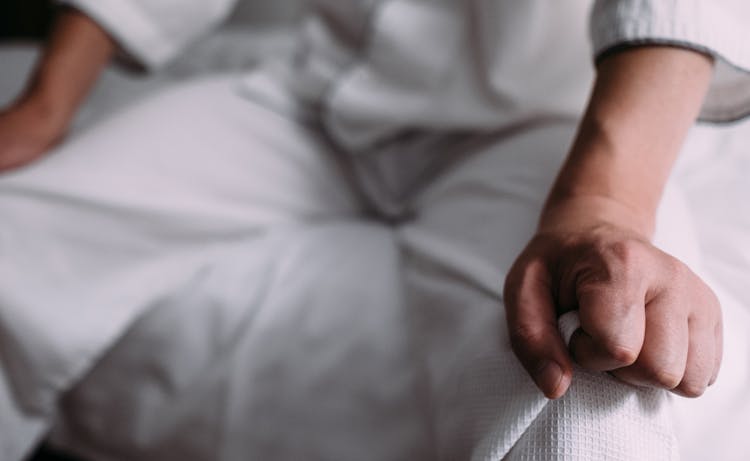 zoom in on a person grabbing their pants around their knees