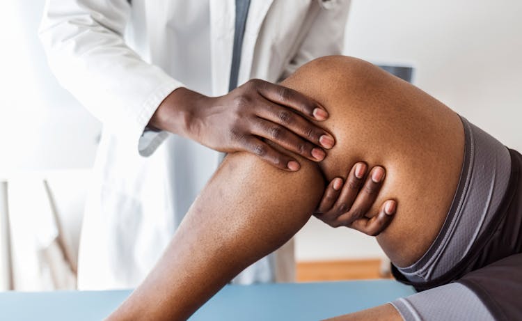 doctor holding clients leg from under the knee