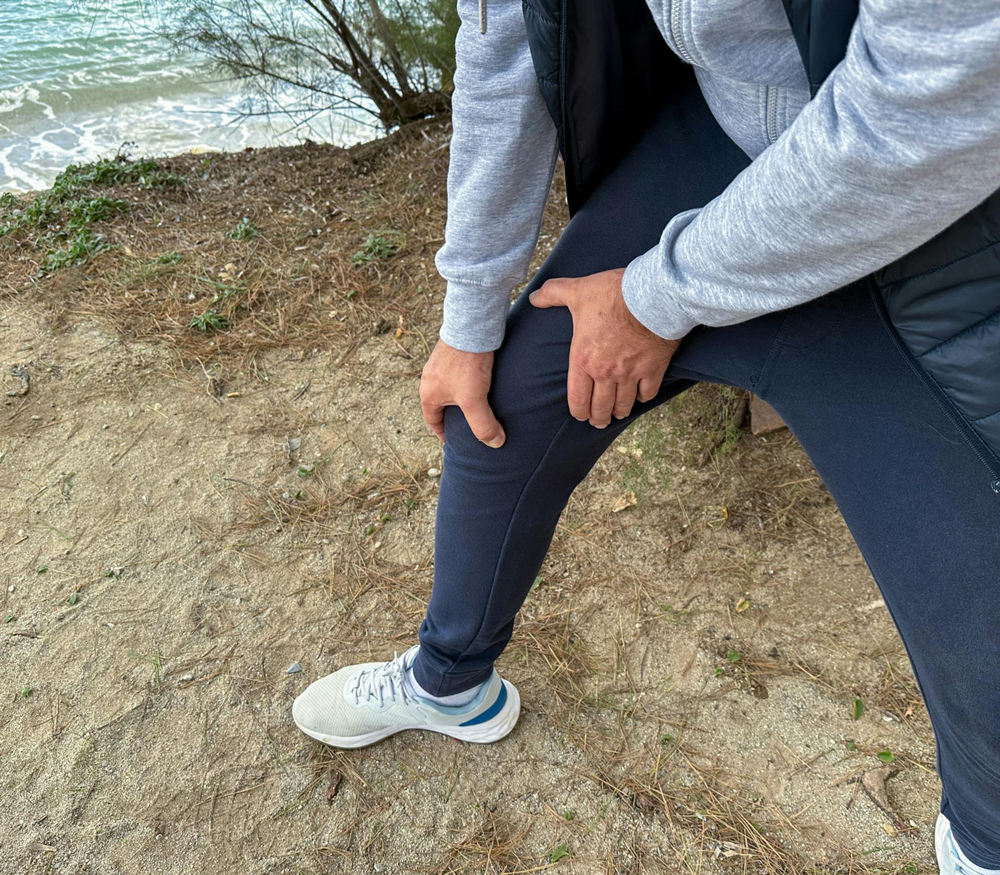 man mid walk grabbing his thigh