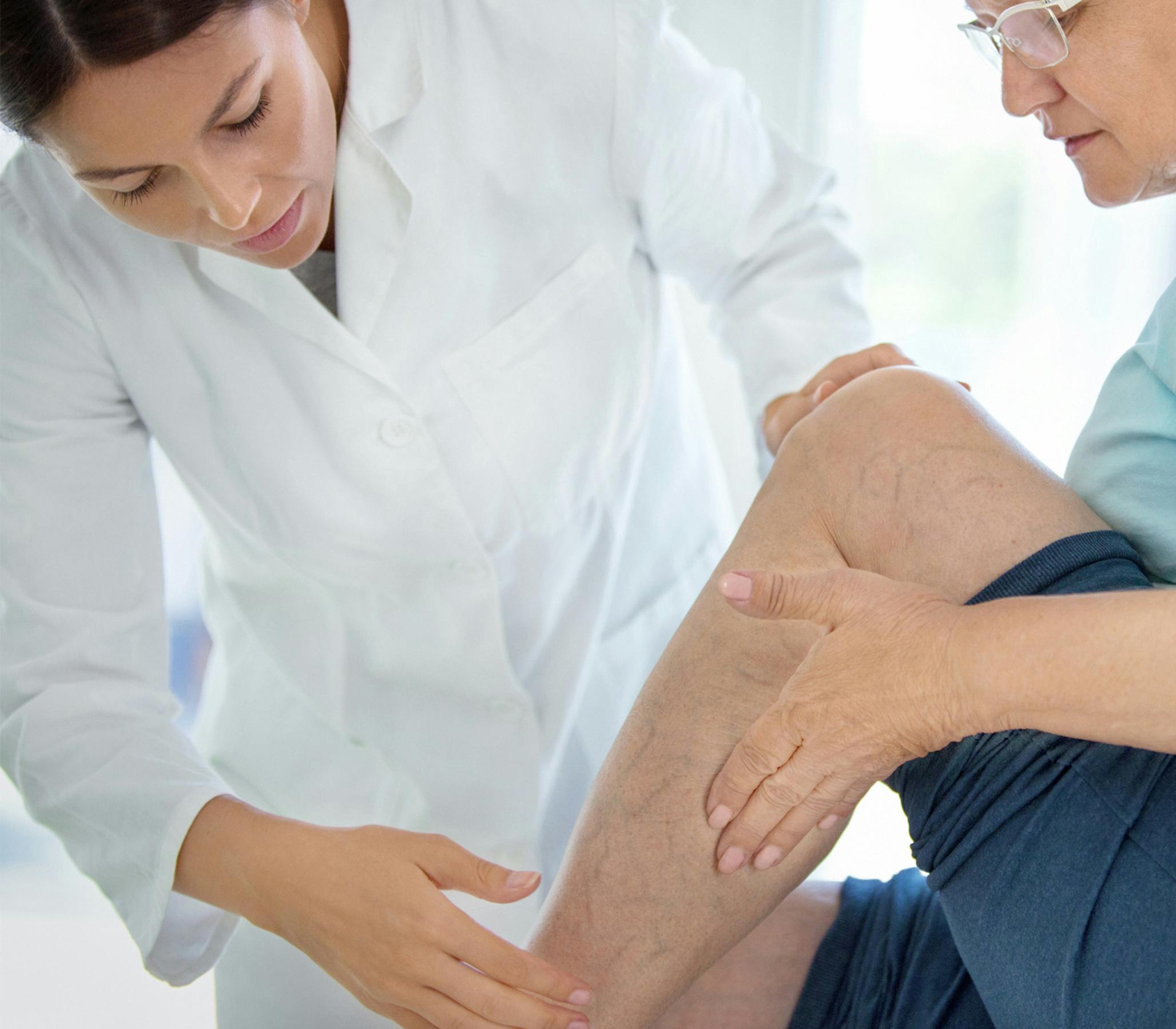 doctor looking at clients lower leg