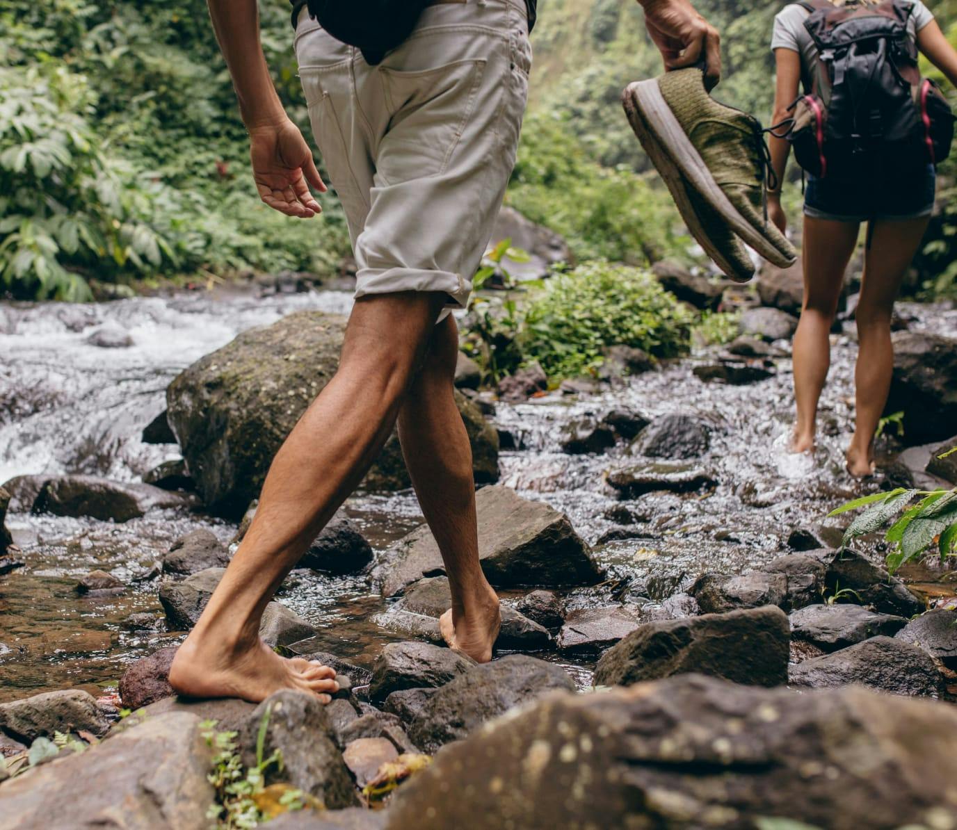 Two people walking through a stream