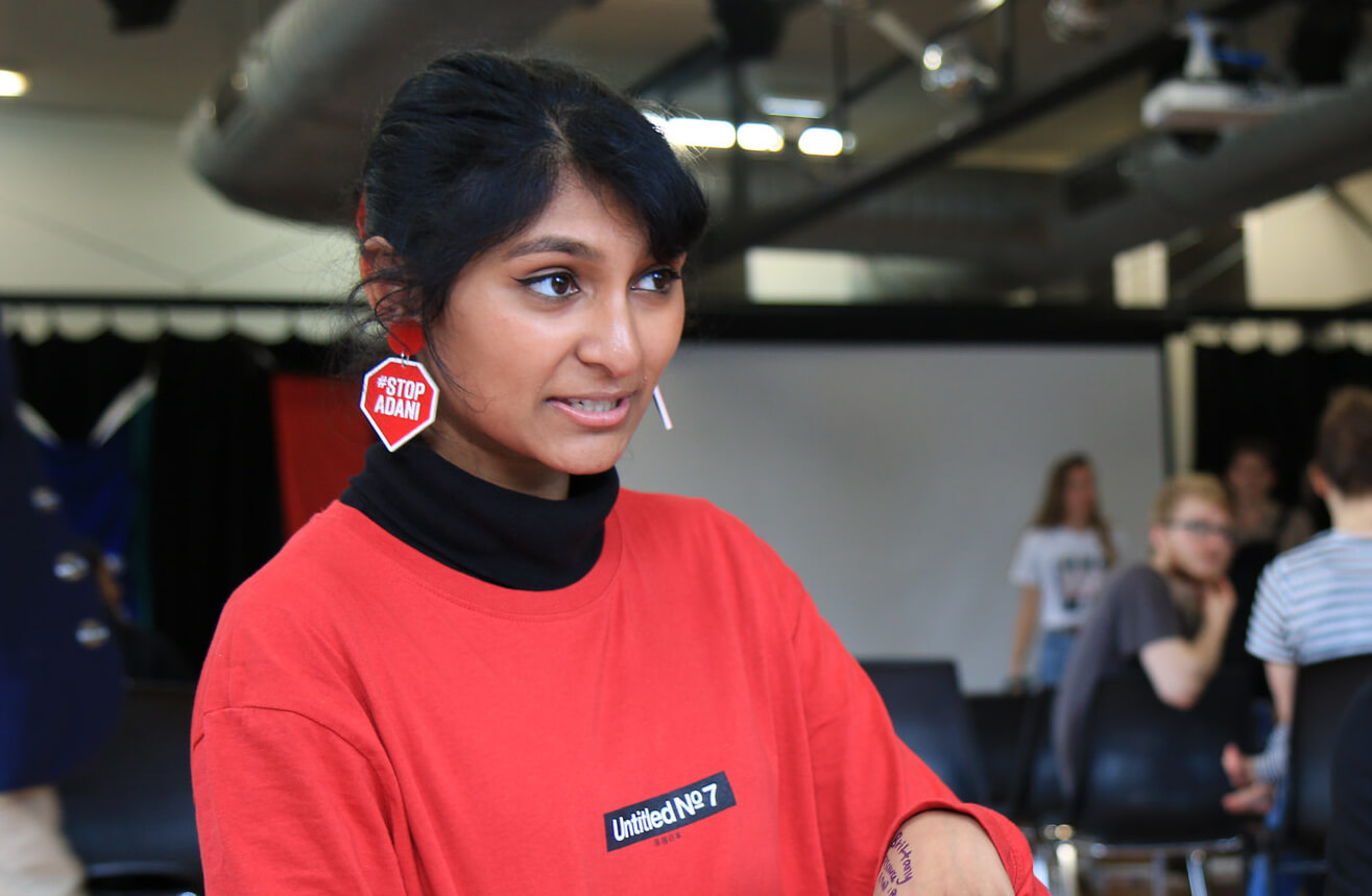 Grace talks at an organising day, wearing her #StopAdani earrings.