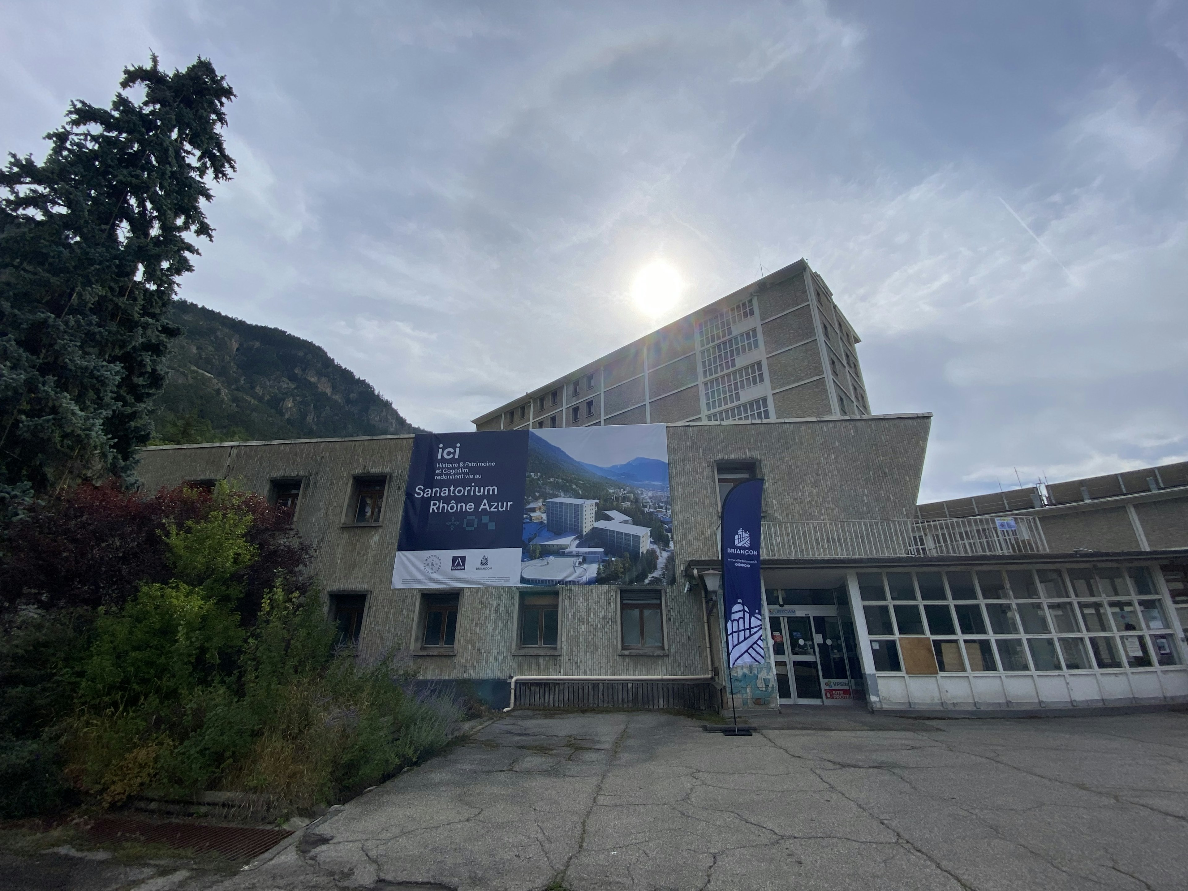 building, office building, advertisement, person, city, urban, path, walkway, plant, tree