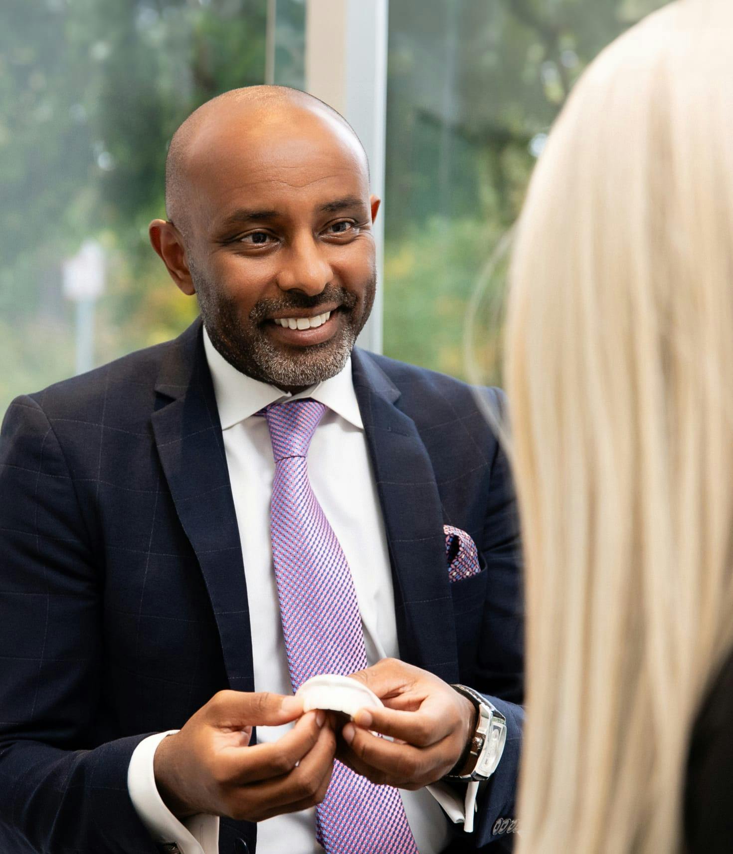 Dr. Sinada smiling holding a device