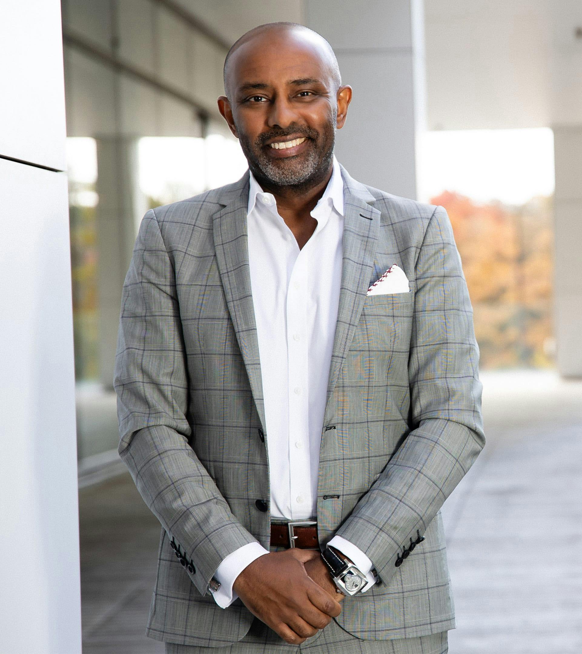 Dr sinada in a gray suit smiling