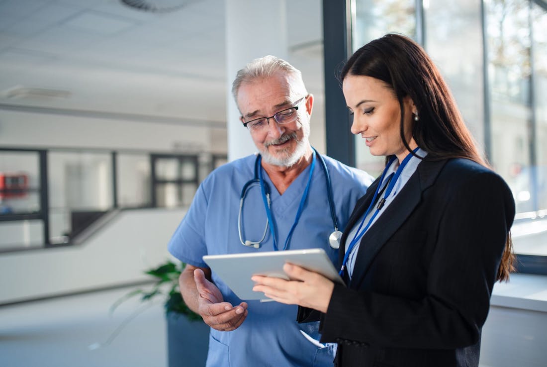 doctor and woman looking at a tablet