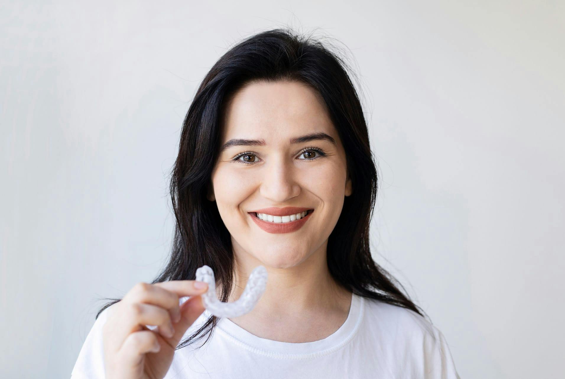 woman holding up teeth guard