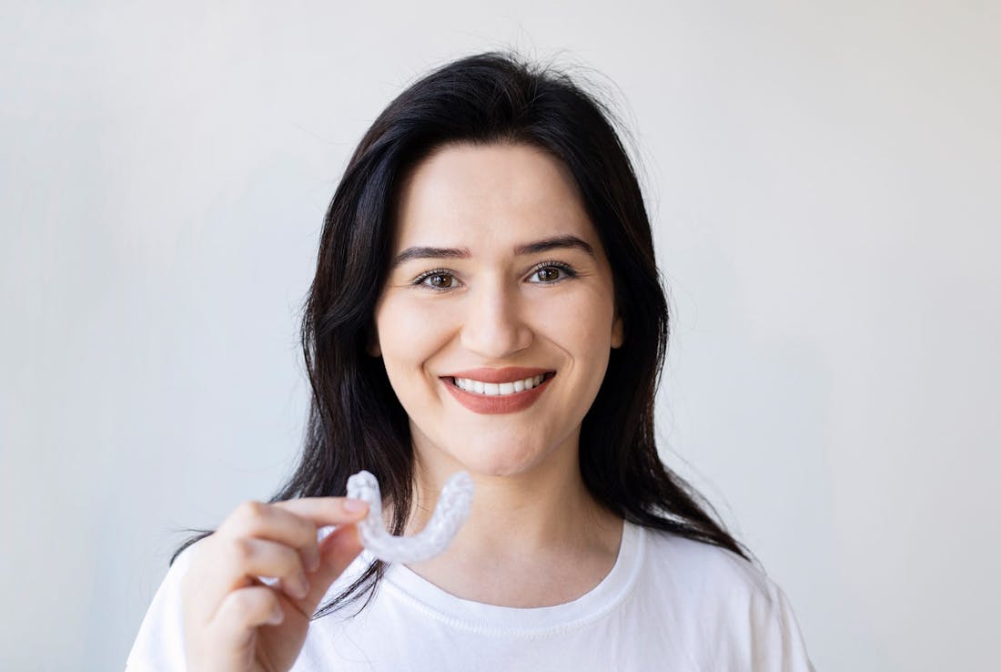 woman holding up teeth guard