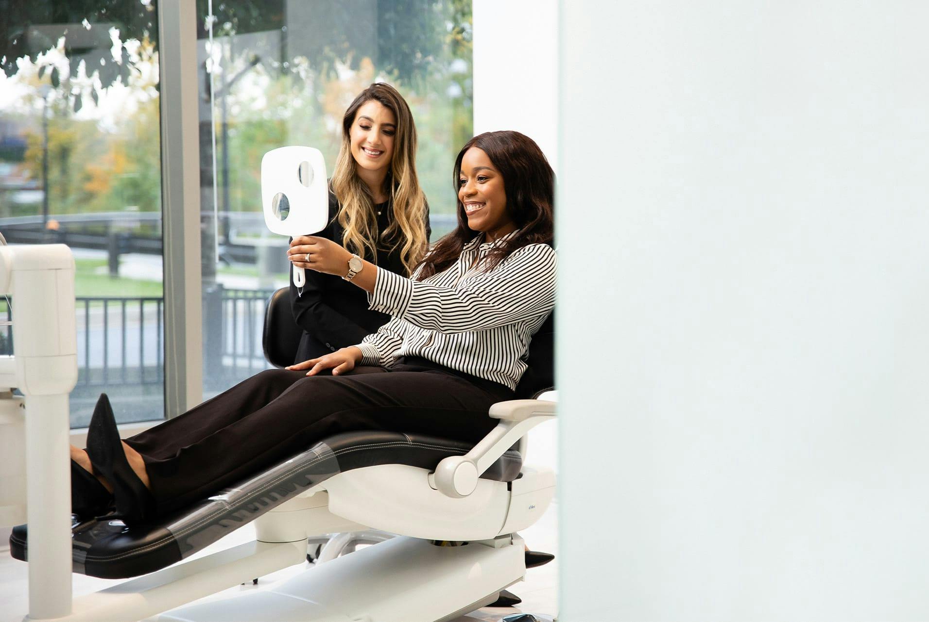 patient looking at her smile in a mirror