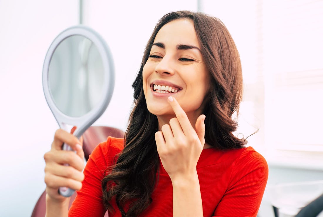 patient looking at her smile in a mirror