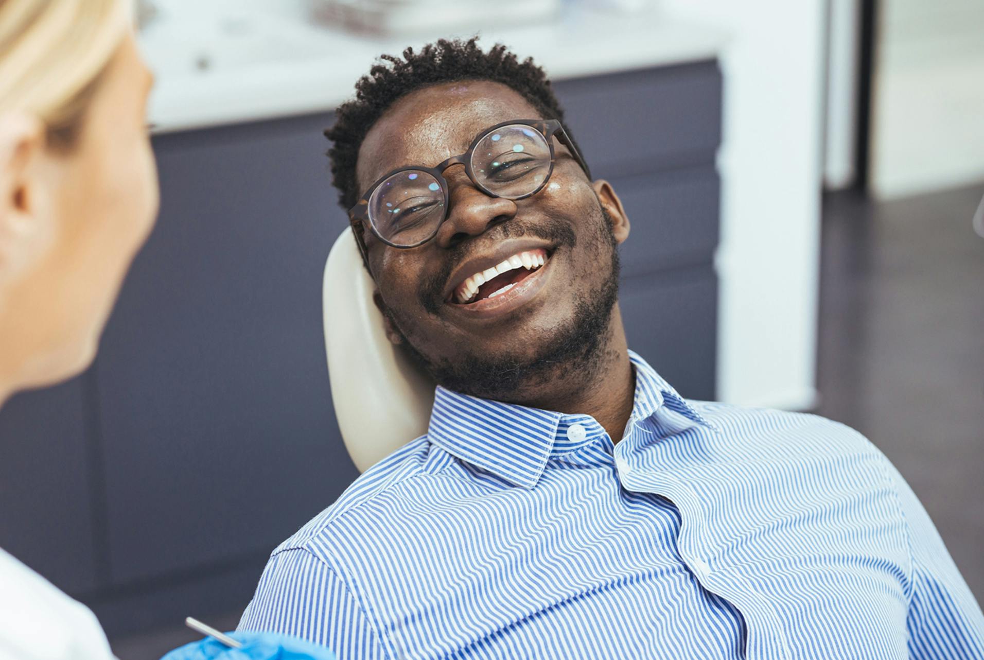 patient smiling, holding a thumbs up