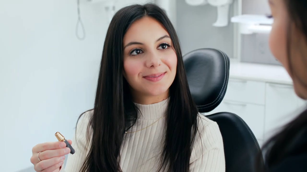 Woman in a chair smiling at another woman