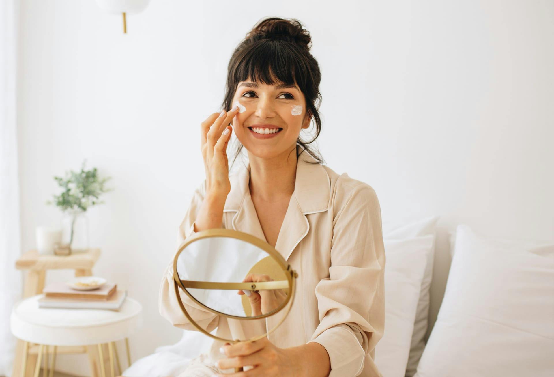 Woman putting lotion on her face