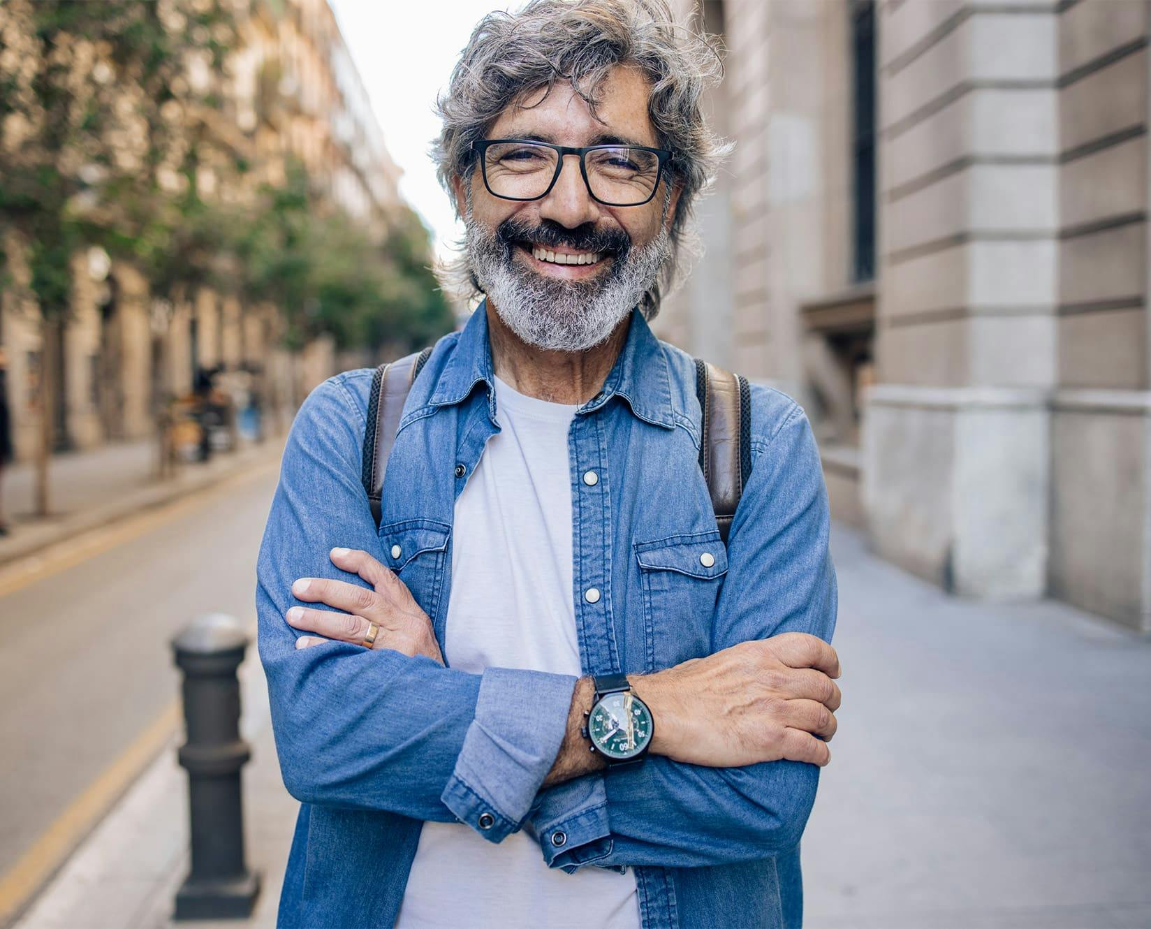 man with salt and pepper hair outside smiling