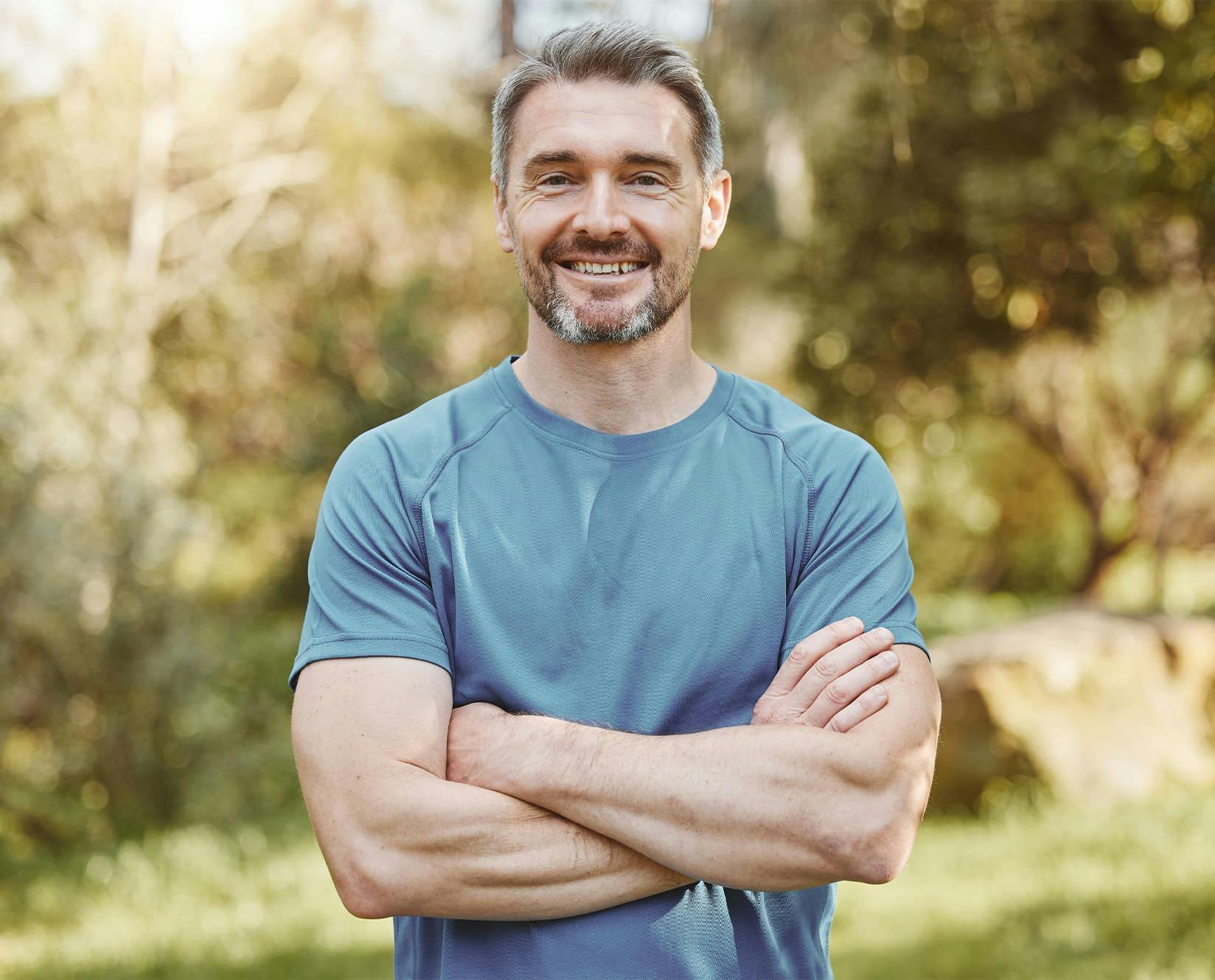 man outside smilling with his arms crossed