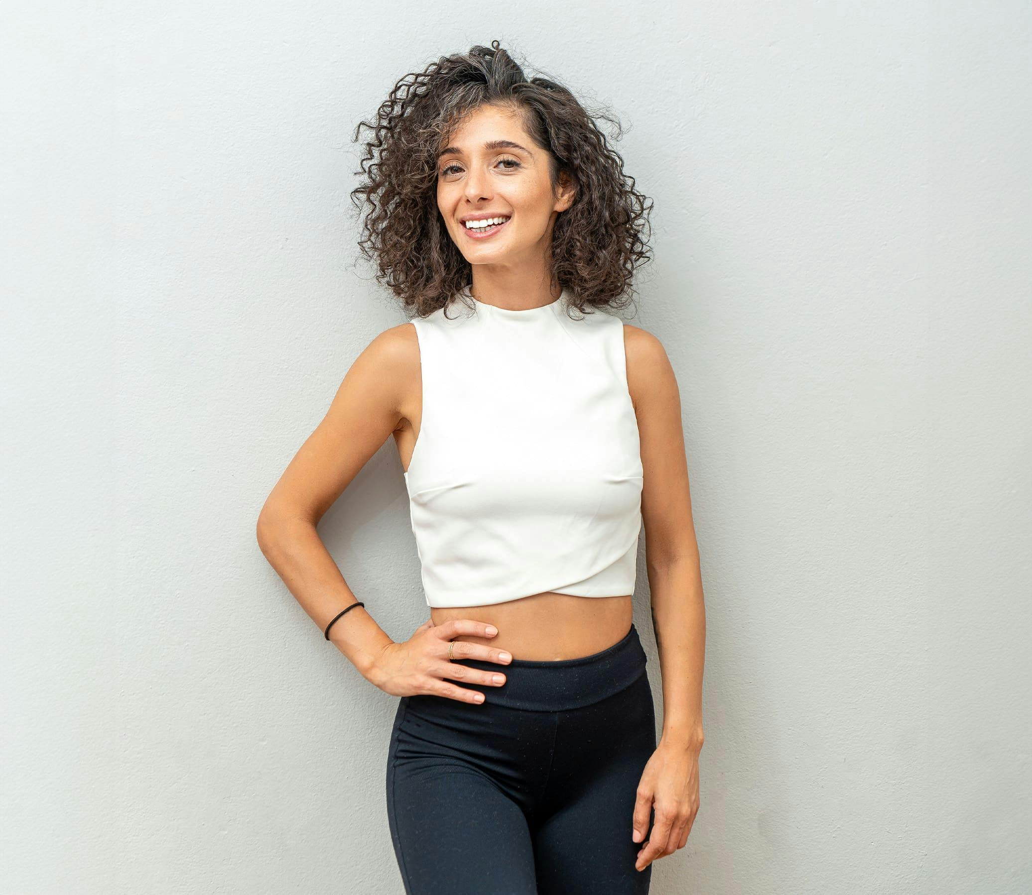 woman in a white crop top and black pants