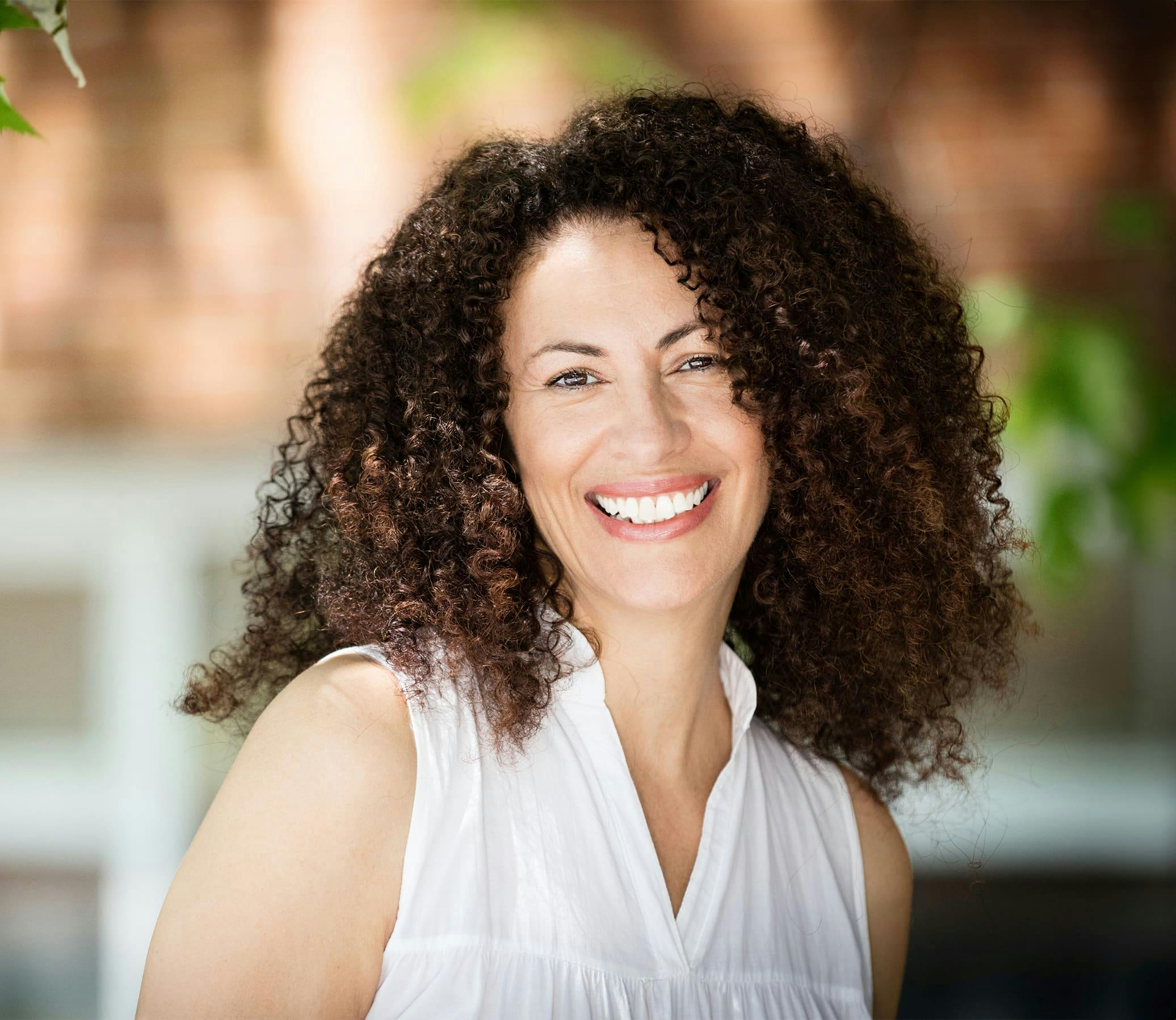 woman with very curly hair smiling