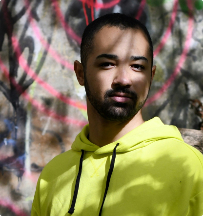 Person in a yellow hoodie looking at the camera.