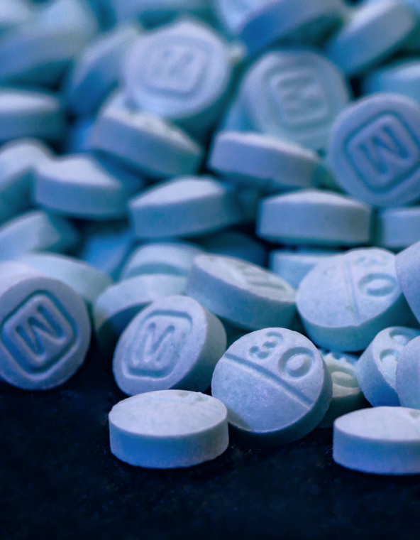 A pile of blue pharmaceutical pills.