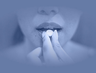 A person placing a pill on their tongue.