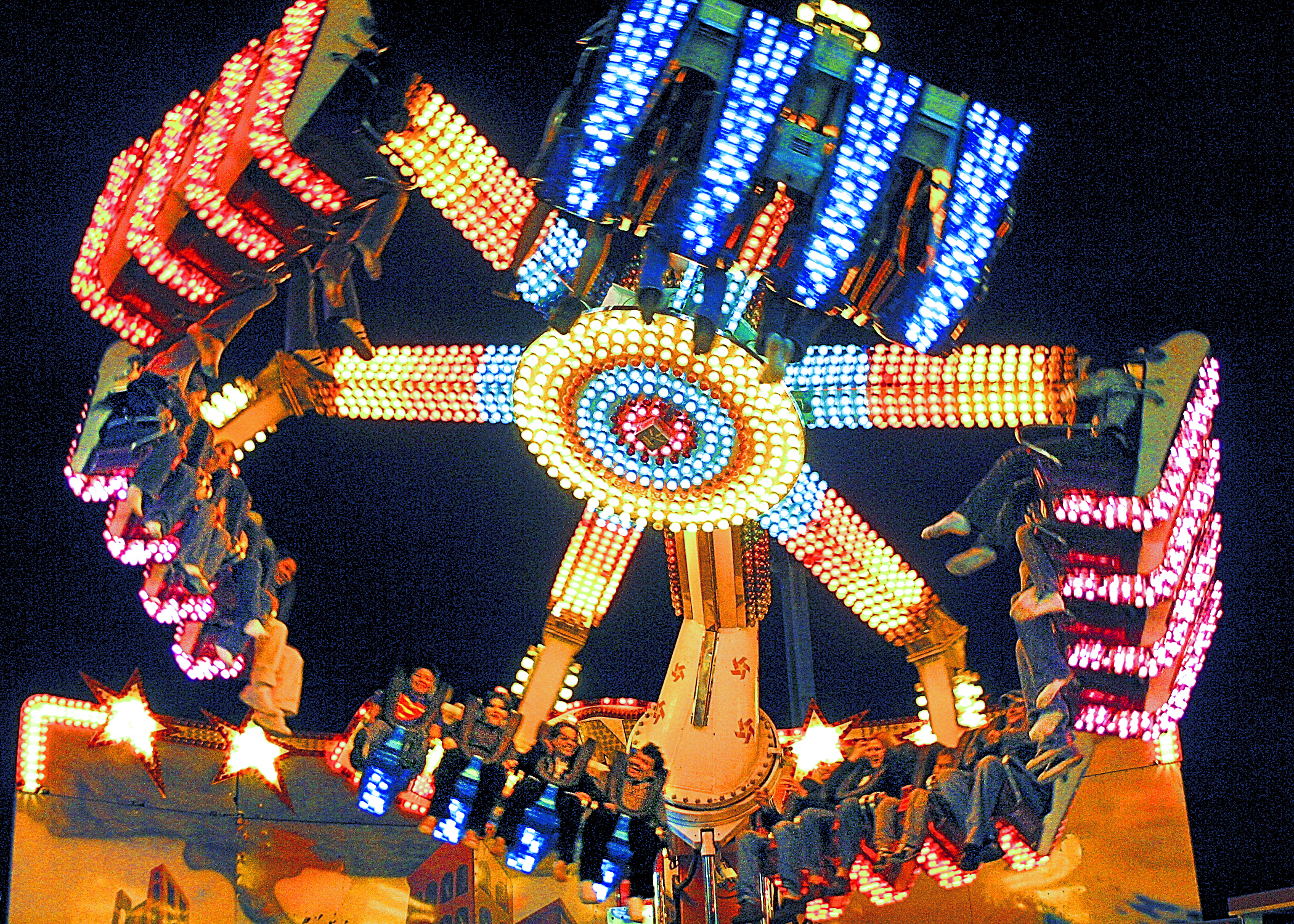 Guests on the El Nino ride, a spinning ride where guests sit strapped into a spinning wheel facing the inner circle with flashing lights.