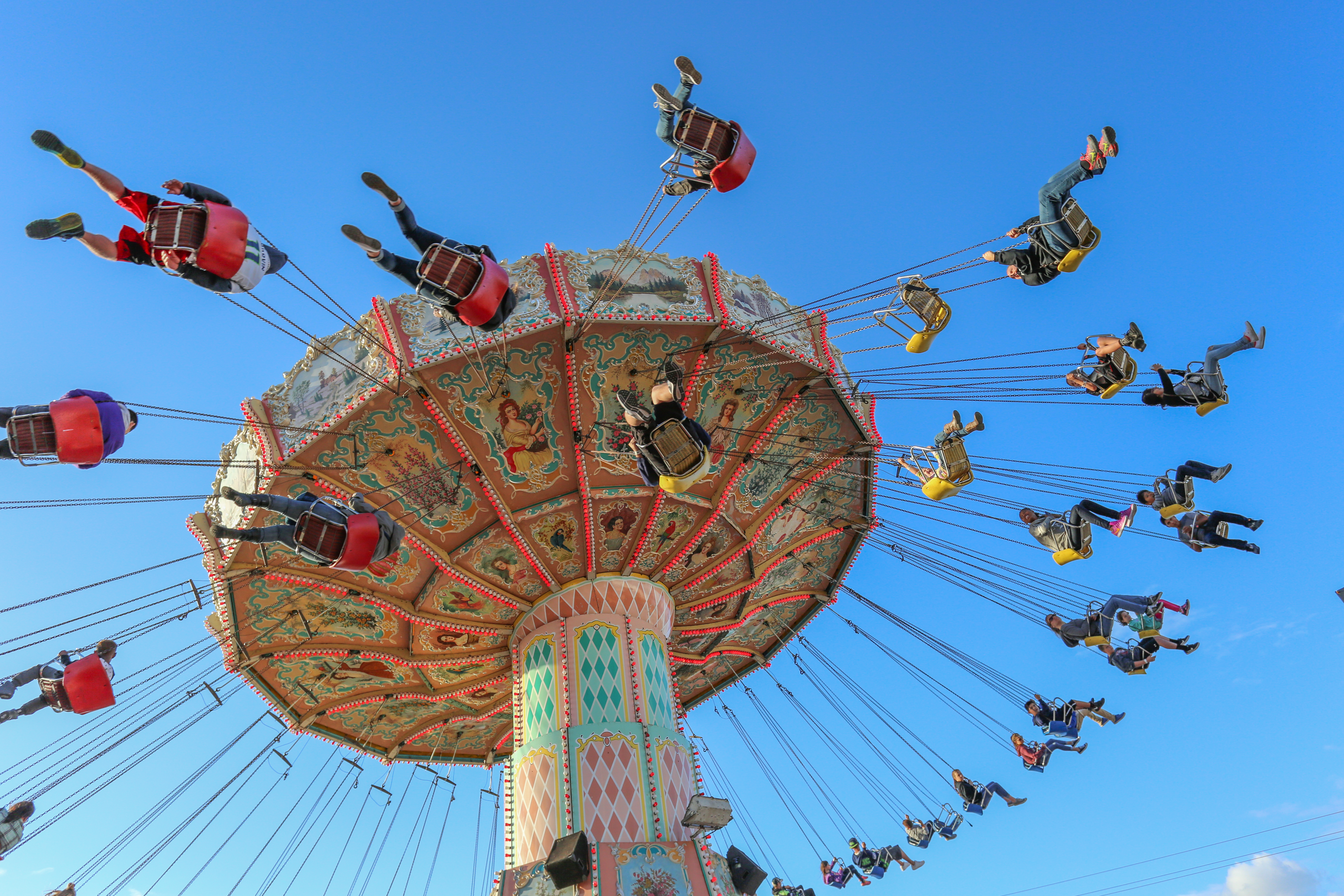 Guests ride the Wave Swinger, a giant tilting ride with swings suspended by chains.