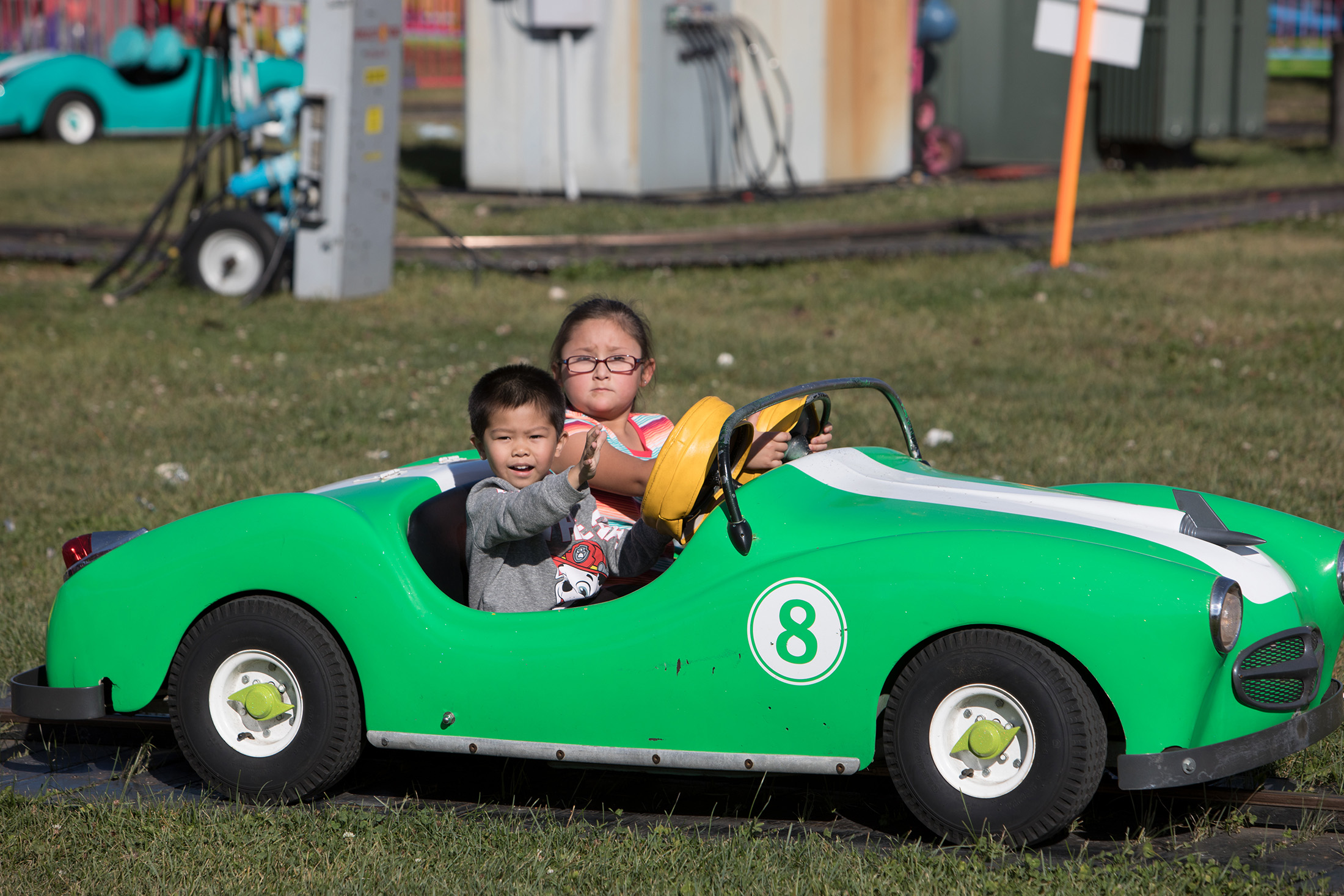 Two small children ride in a green car on the Turnpike ride.