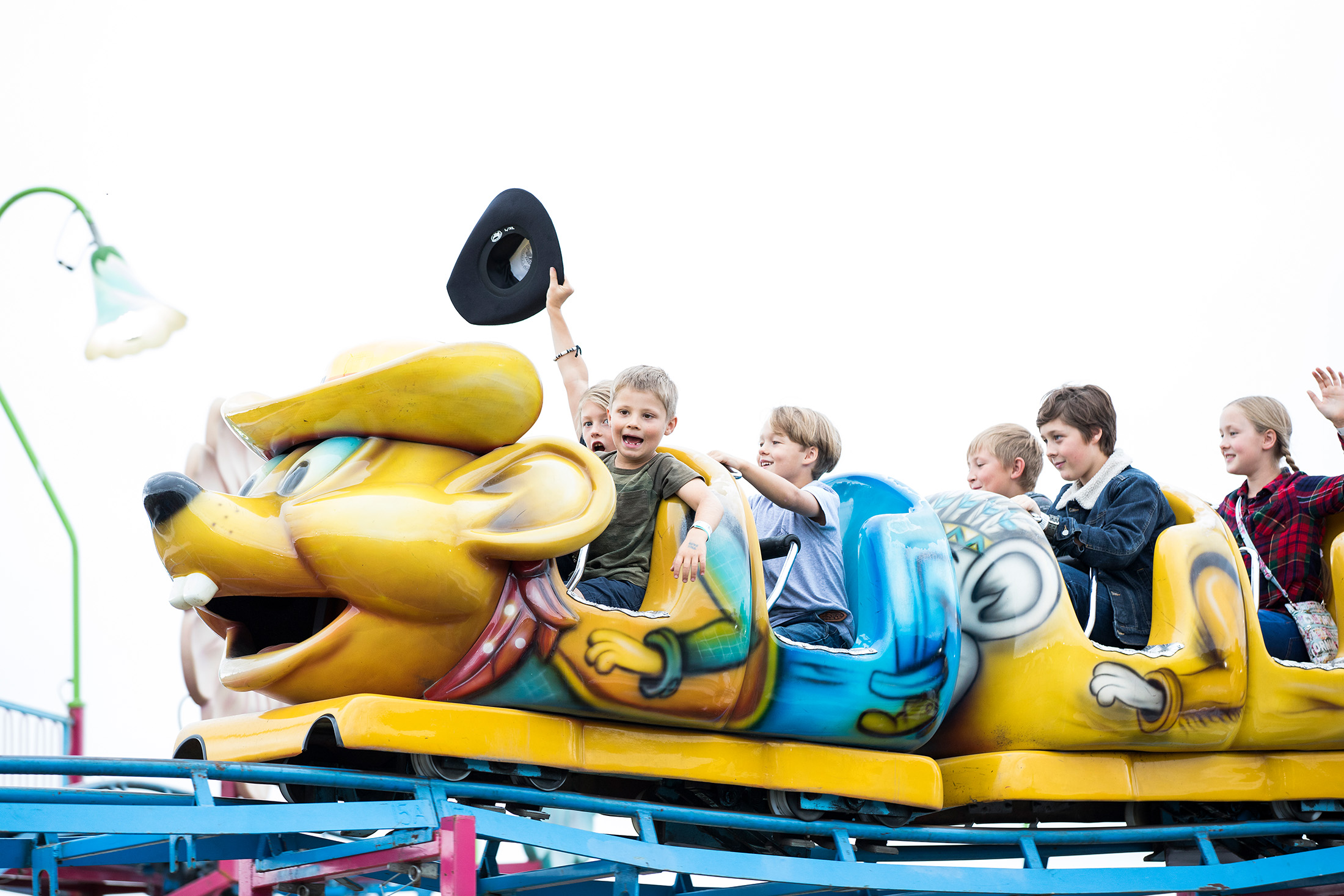 Children ride the Speedy Coaster, a small roller coaster with mouse-themed car