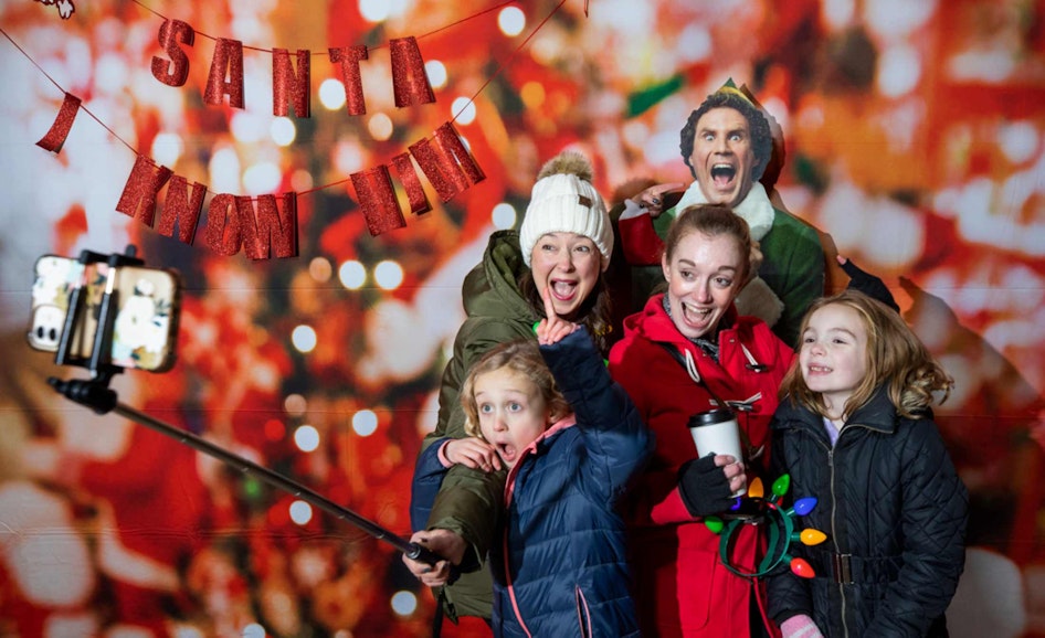 A family poses at the holiday selfie station