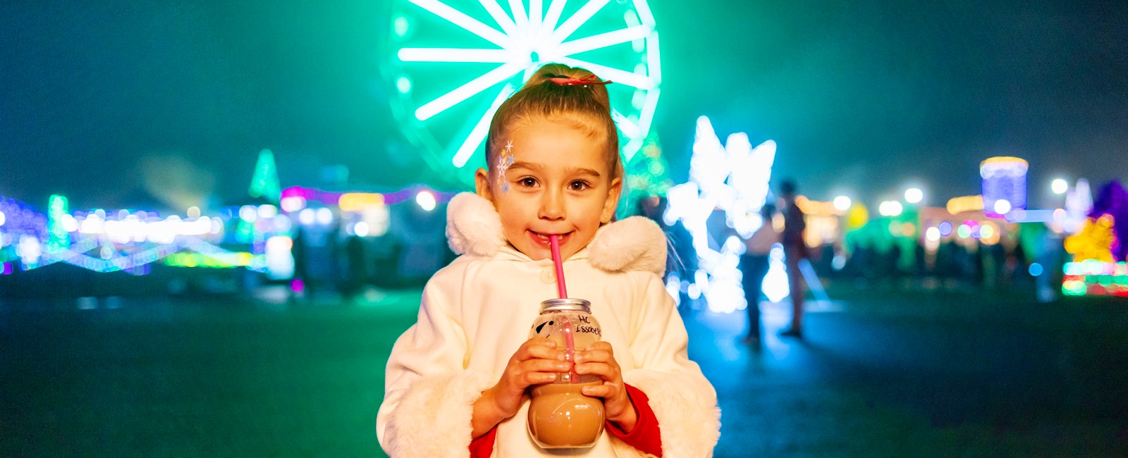 Little Girl drinking coco in front of Wonder Wheel at Holiday Magic