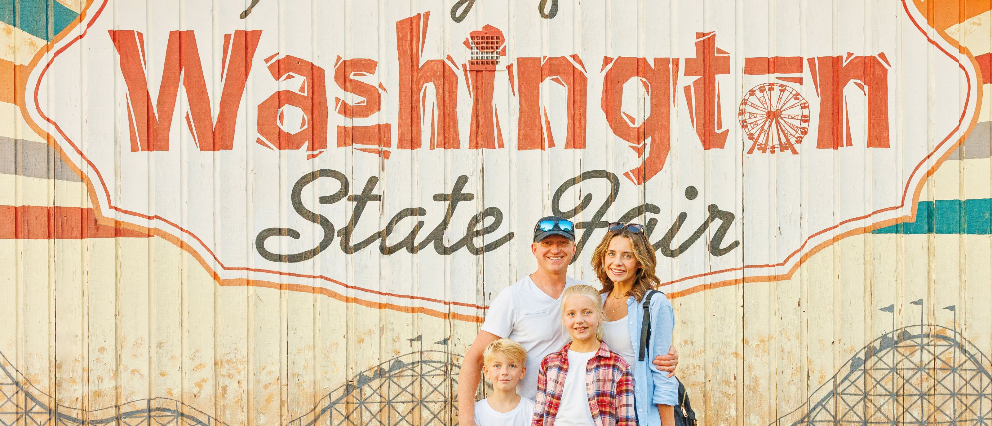 family in front of washington state fair mural