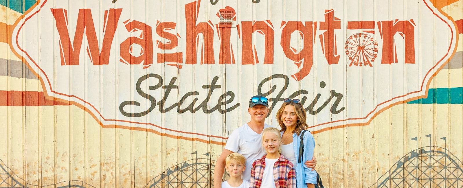 family in front of washington state fair mural
