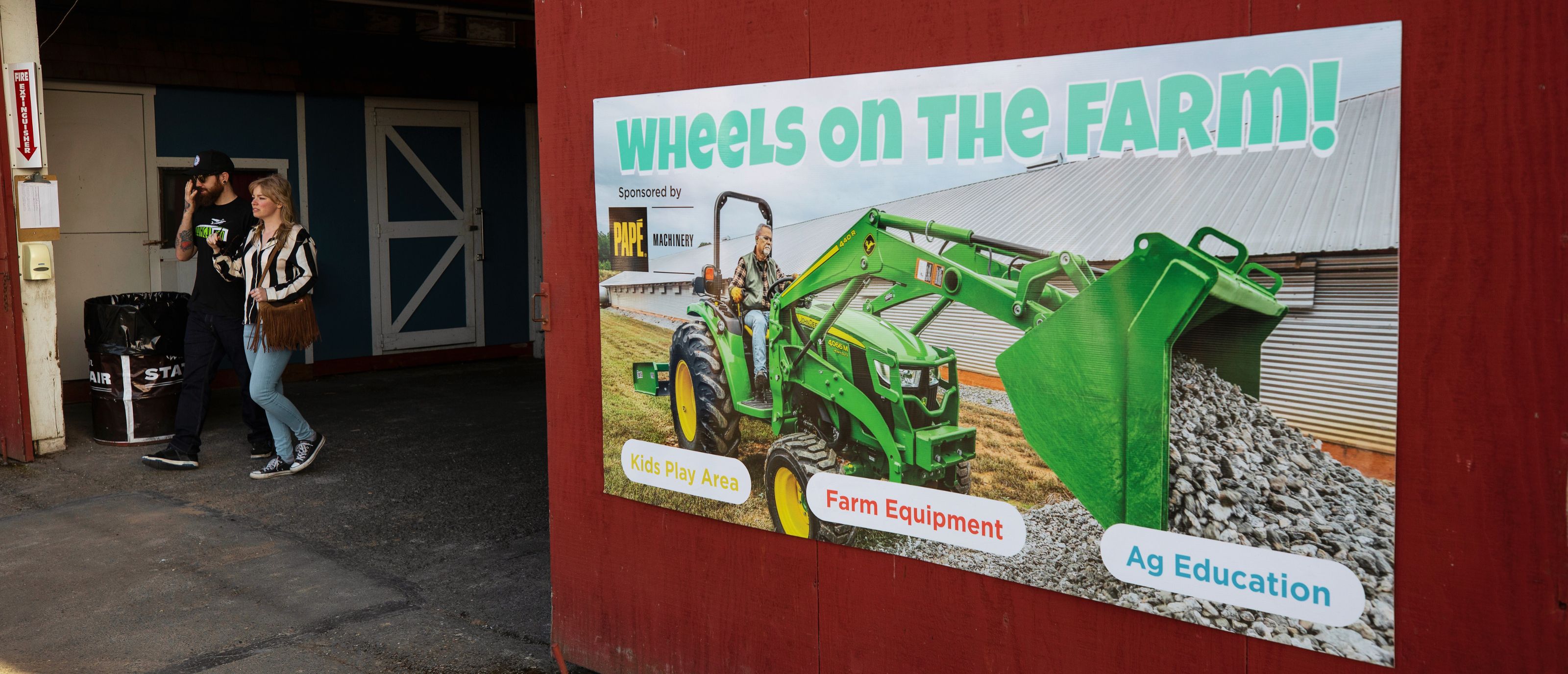 Entrance to Wheels on the Farm, with couple walking out of barn