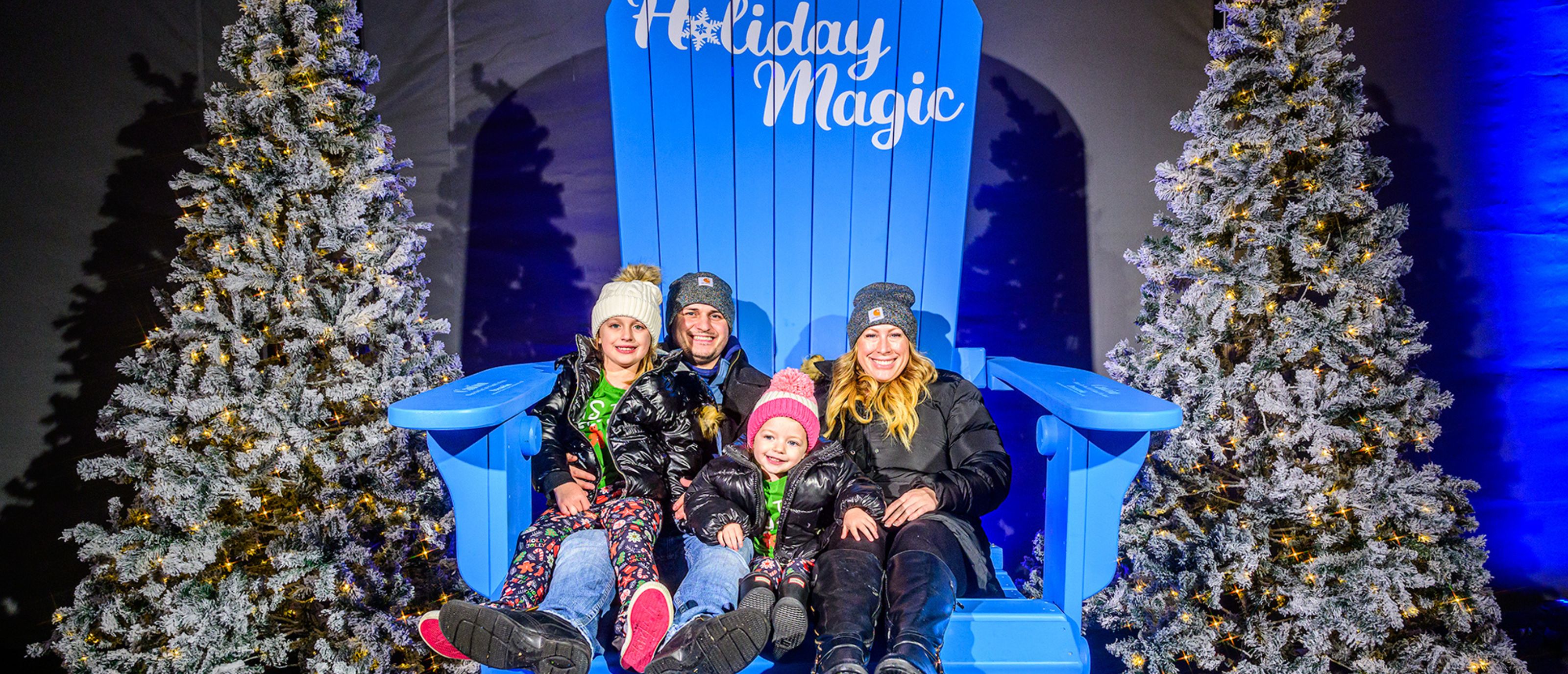 family sitting in giant photo op chair