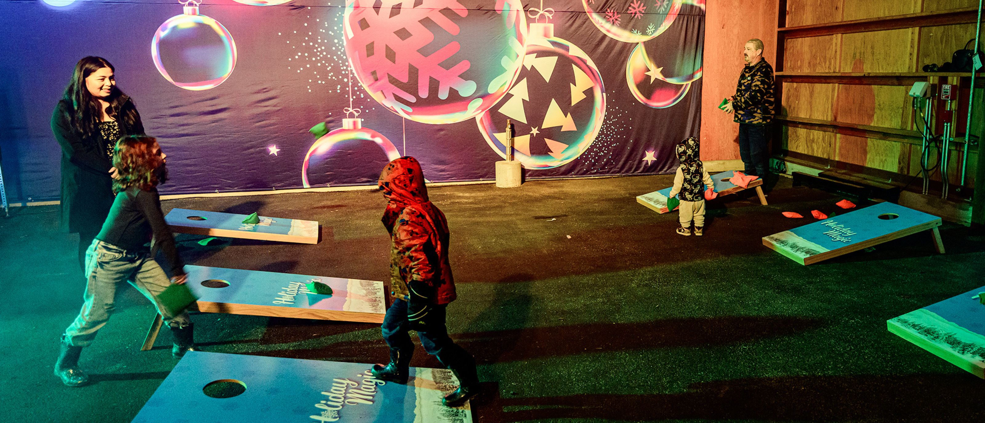 family playing corn hole in winter fun