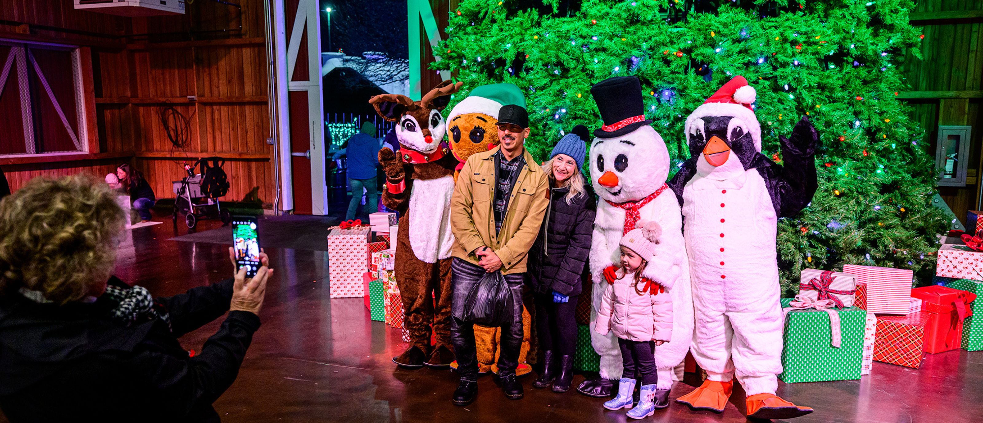 Family taking photos with Santa's Cheerful Friends in Santa's Clubhouse