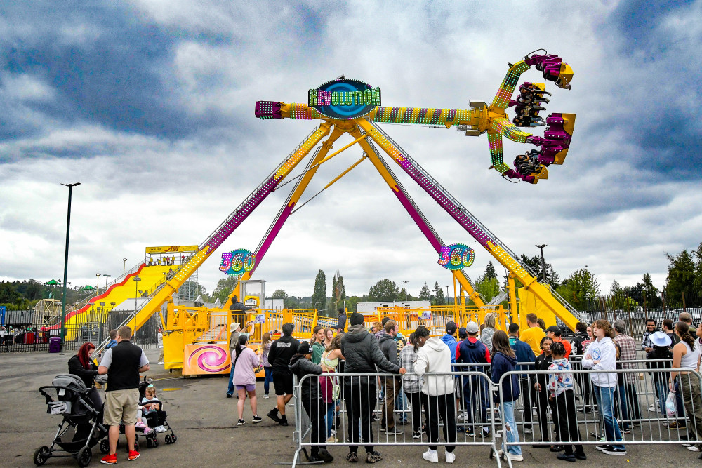 Crowds in line in front of the Revolution 360 ride, a colorful swinging spinner ride that rotates guests 360 degrees.