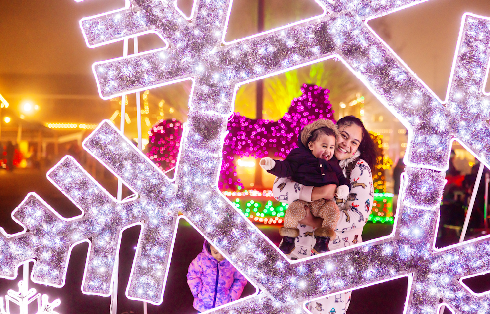 A mom and her baby in a light-up snowflake display