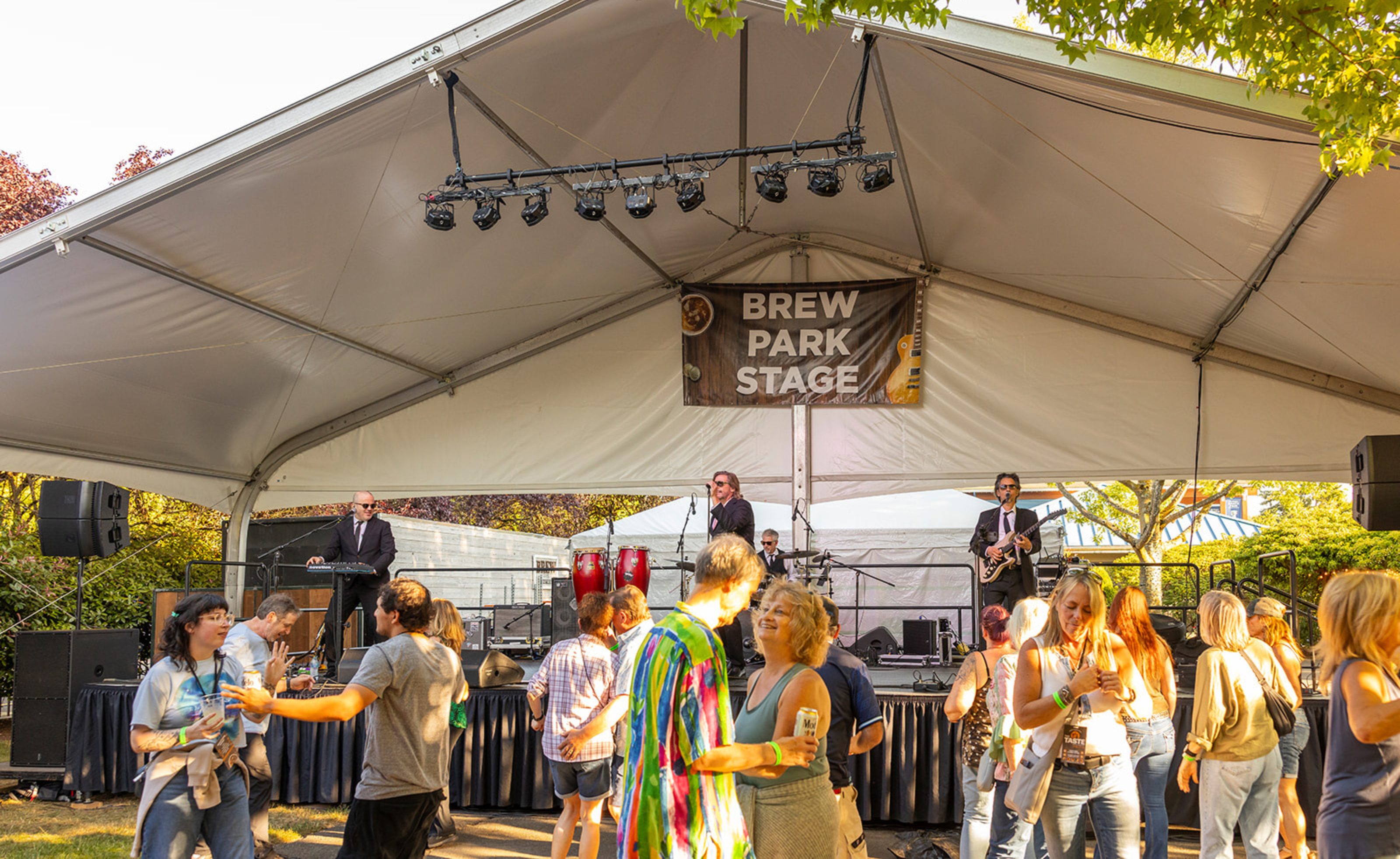 People dancing and band performing at brew park stage